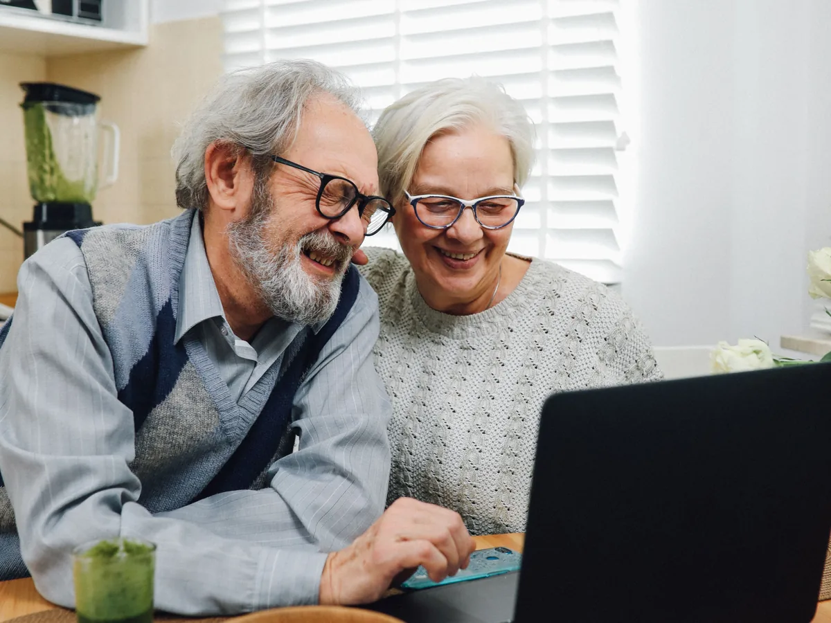 Couple de retraités souriant à la maison